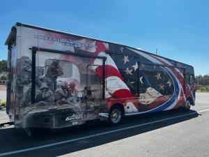 盖恩斯维尔Santa Fe Palms RV Resort的一辆挂着美国国旗的公共汽车