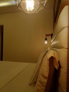 林贝First International Inn Downtown的卧室配有一张床,墙上有灯