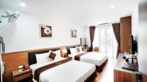 河内Lam Anh Hotel Dương Nội Hà Đông的酒店客房设有两张床和电视。