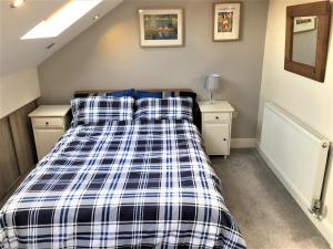 伦敦Newly Refurb Period 1-Bed Apartment with Roof Terrace, 47 sqm-500 sqft, in Putney near River Thames的一间卧室配有一张带蓝色和白色拼盘床单的床。