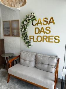 弗洛里亚诺波利斯Casa das Flores的客厅配有沙发和阅读卡萨花的标志