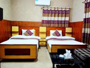 卡拉奇Jinnah Airport Hotel的一间卧室配有两张床和一张带篮子的桌子