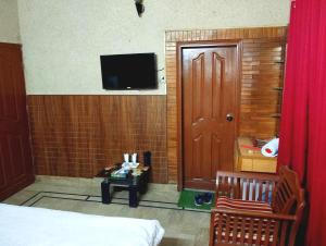 卡拉奇Jinnah Airport Hotel的一间设有床铺和墙上电视的房间