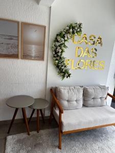 弗洛里亚诺波利斯Casa das Flores的客厅配有沙发和墙上花圈
