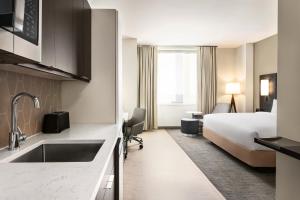 皇后区Residence Inn by Marriott New York JFK Airport的酒店客房带一张床和一个厨房