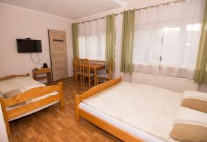 斯克拉斯卡波伦巴Willa Nova - Centrum的一间卧室配有两张床和一张桌子及一台电视机