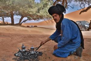 梅尔祖卡Golden Camp & Oasis的一个人在火上点茶壶