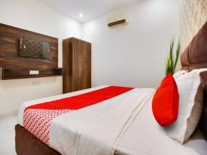 卢迪亚纳OYO Flagship Golden A的一间卧室配有一张带红色枕头的床