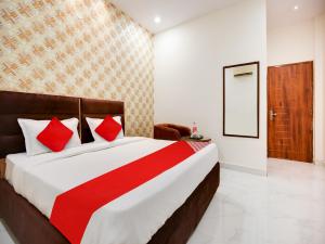 卢迪亚纳OYO Flagship Golden A的一间卧室配有一张带红色枕头的大床