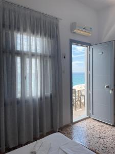 马拉松坎博斯Chrisopetro Rooms的卧室设有滑动玻璃门,享有海景