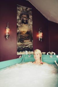 弗兰季谢克矿泉镇波希米亚酒店的坐在雕像前浴缸中的女人