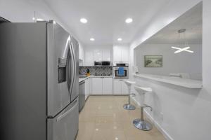 阳光岛滩Ocean View 15th floor Apartment Sunny Isles的厨房配有白色橱柜和冰箱。
