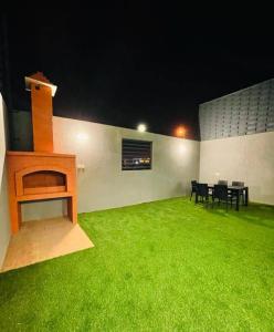 艾卜哈شاليهات الود的客房设有带桌椅的绿色庭院。