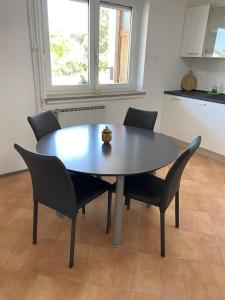 科佩尔Apartma na vinski kmetiji的厨房里配有餐桌和椅子