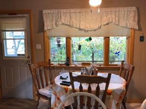 Iron BridgeCliff’s Place的一间带桌椅和窗户的用餐室