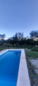 吉亚迪诺镇Casa V.Giardino pileta y cochera的一座绿树成荫的蓝色游泳池