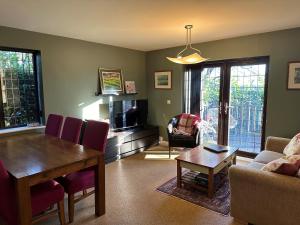 EcclesallBeechcroft Corner House的一间带木桌的客厅和一间带沙发的客厅。