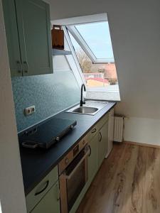 梅明根Ferienwohnung Allgäu 5的一个带水槽和窗户的小厨房