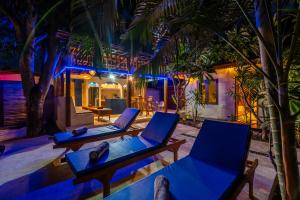 吉利阿尔Paradise Villa Gili Air的棕榈树间配有两把椅子和一张桌子