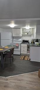 加蒂诺Le Cent Onze的厨房配有白色橱柜、桌子和用餐室。