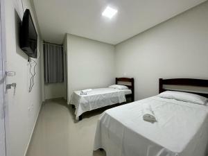 邦热苏斯-达拉帕Hotel Brisas的一间设有两张床和电视的房间