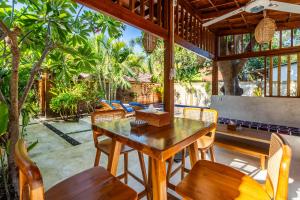 吉利阿尔Paradise Villa Gili Air的户外用餐区配有木桌和椅子