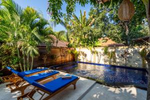 吉利阿尔Paradise Villa Gili Air的一个带蓝色躺椅的游泳池和一个游泳池