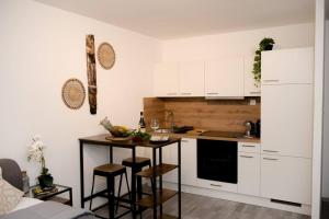 维也纳Entire Tulum Apartment, in the Center of Vienna的厨房配有白色橱柜和带凳子的小桌子。
