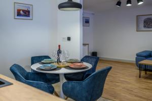 蒂米什瓦拉Five Stars Apartment的一间带桌子和蓝色椅子的用餐室