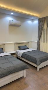 Ash Shuqraشاليه الشروق的两张床铺位于带墙壁的房间