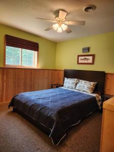 HesselRiverfront~On ATV Trials~Near Mackinac Island的一间卧室配有一张带吊扇的床