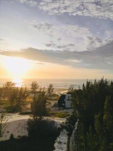 雅瓜鲁纳O Chalé da Praia的日落时在海边的露营车