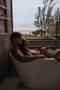 雅瓜鲁纳O Chalé da Praia的躺在浴缸里的男女