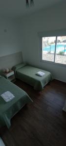 卡法亚特Colores De La Quebrada的客房设有两张床和窗户。