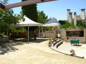 阿尔贝罗贝洛Trullo Malvisco的一个带两把白色遮阳伞和壁炉的庭院