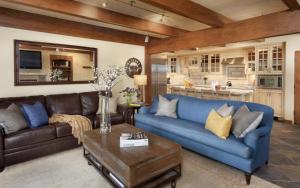 斯诺马斯村Timberline Condominiums 2 Bedroom Premier Unit C1D的一间带蓝色沙发的客厅和一间厨房
