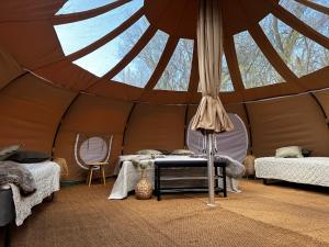 IdestrupRomantik Luxus Glamping 2的帐篷配有两张床和一张桌子