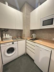 马德里MAD COCO Apartamento Frente al Prado的厨房配有白色橱柜和洗衣机。