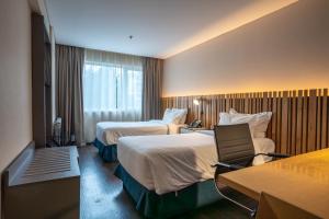 圣卡洛斯-德巴里洛切Hampton By Hilton Bariloche的酒店客房设有两张床和窗户。