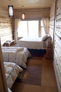 AchaoHotel Boutique Antukenu的一间卧室设有两张床和窗户。