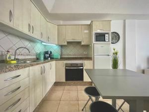 洛斯克里斯蒂亚诺斯CASA VARGAS-TENERIFE的厨房配有白色橱柜和桌椅