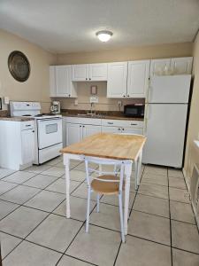 圣徒皮特海滩Oasis Palms Resort的厨房配有木桌和白色冰箱。