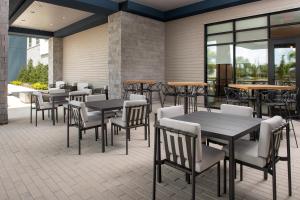 奥兰多Hampton Inn Orlando Southeast Nona的餐厅设有桌椅和窗户。