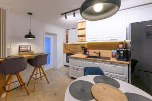 蒂米什瓦拉Five Stars Apartment的厨房配有白色橱柜和桌椅