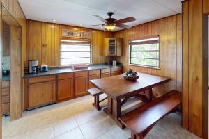塔维涅Fair Wind II的厨房配有木桌和吊扇