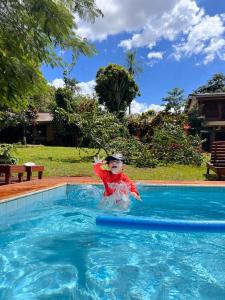 伊瓜苏港Mainumby- Colibri Posada的一个小孩在游泳池里