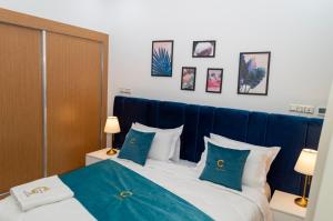 达赫拉Hotel Golden Sunset Dakhla的一间卧室配有一张带蓝色床单和枕头的床。