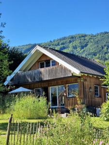 阿特湖畔翁特拉赫Countryhouse Lake Attersee - Sauna, Kamin, Seeblick的前面有围栏的木屋