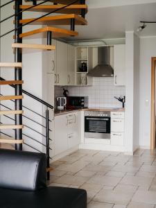 埃希特纳赫兰登哈弗住宿加早餐旅馆的厨房配有白色橱柜和螺旋楼梯