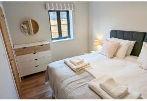 贝里圣埃德蒙兹Meadow View Lodges的卧室配有带毛巾的大型白色床